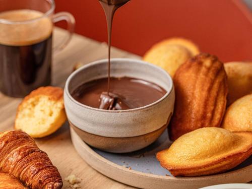 Se vierte una taza de chocolate en un pan. en ibis Annecy Centre Vieille Ville, en Annecy