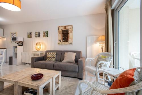 a living room with a couch and a table at Les Oyats - Parking - Balcon - Plage in Le Touquet-Paris-Plage