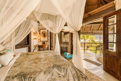 een slaapkamer met een hemelbed bij Harmonie in Rivière Noire
