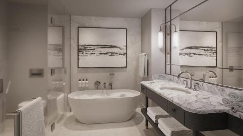 a bathroom with a large tub and a sink at InterContinental Hotels Table Bay Cape Town by IHG in Cape Town