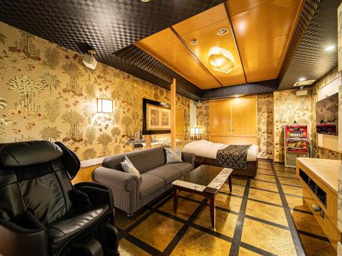 a living room with a couch and a bed at Hotel LaLa (Adult Only) in Sakai