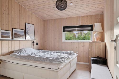 a bedroom with a bed and a window at Active Coastal Holiday In Cozy Cottage in Strandlyst