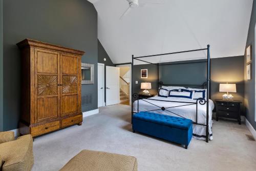 a bedroom with a canopy bed and a blue couch at SS52: 52 Surfsong in Kiawah Island