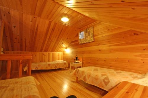 ein Zimmer mit zwei Betten in einer Blockhütte in der Unterkunft Holiday Home Marja-aapa 3 in Luosto