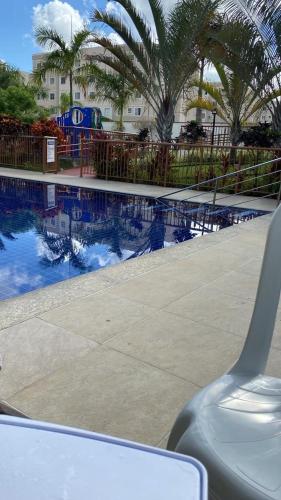 a swimming pool with palm trees and a resort at Apartamento em Maceió in Maceió