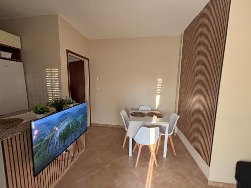 a dining room with a table and a large screen tv at Modern Apartment - MIND District, Fiera Milano Rho in Baranzate