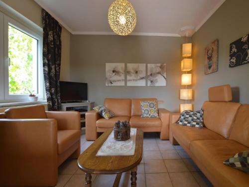 a living room with a couch and a table at Ondenval Stay with Sauna in Waimes