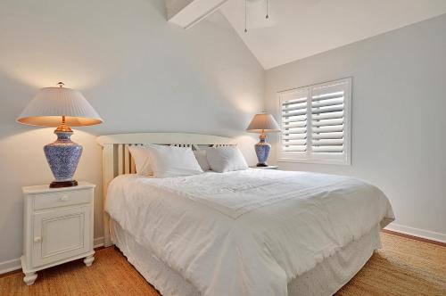 een slaapkamer met een wit bed en 2 lampen op tafels bij WS4463: 4463 Windswept in Kiawah Island