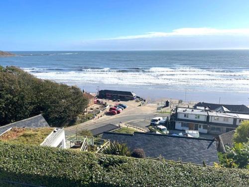 a view of the ocean with cars parked on a road at Cliff Top Apartment in Filey