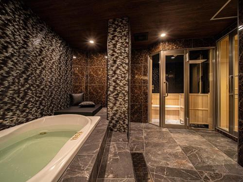 een badkamer met een bad in een kamer bij Hotel LaLa (Adult Only) in Sakai