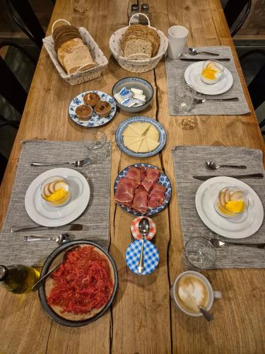 a wooden table topped with plates of food and eggs at Molino del Corregidor in San Román de Cameros