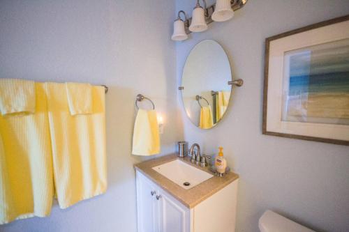 un baño con lavabo y espejo en Perfect Ocean View - The Sands - K0003A, en Croatan Shores