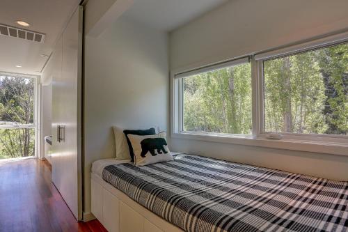 a bed in a room with two large windows at Neal Creek Retreat in Mount Hood