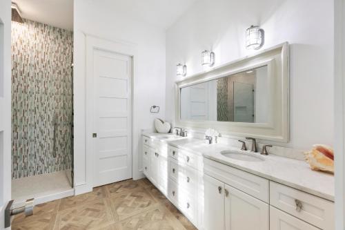 a white bathroom with two sinks and a mirror at PALM2905: 2905 Palm Blvd. in Isle of Palms