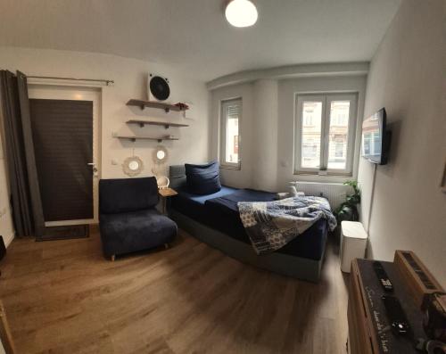 een slaapkamer met een bed en een stoel erin bij ModernesMiniZimmer-Stadtnah-SelfCheckIn-Parkplatz in Neurenberg