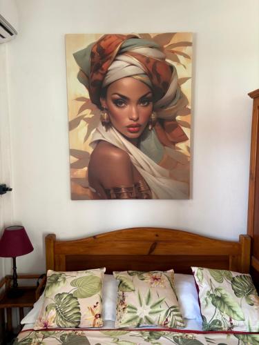 Un cuadro de una mujer negra colgado en una pared en Logement « Alpinia », en Capesterre