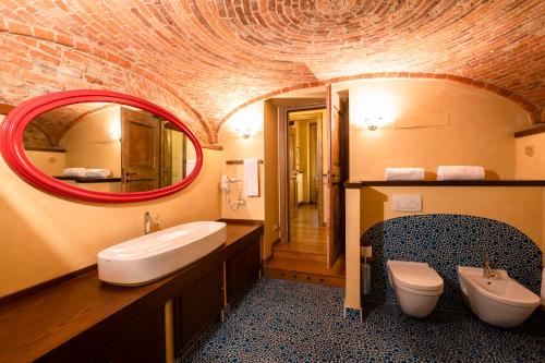 Un baño con lavabo, espejo e inodoro. en Corte Del Passone, en Montevecchia
