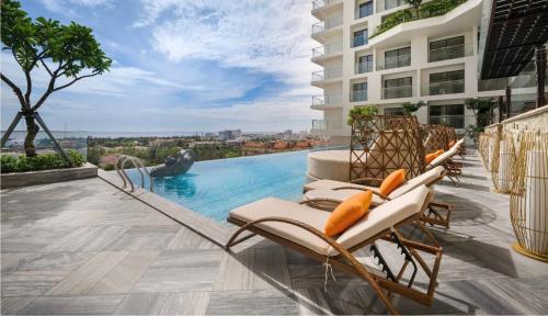 eine Gruppe von Stühlen auf einem Pool in der Unterkunft Khách Sạn Apec Mandala Whyndham Tuy Hoa -Phú Yên in Phước Hậu (1)