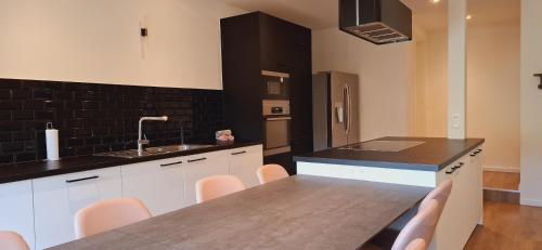 a kitchen with a sink and a table with chairs at Chez Ellen in Tavigny
