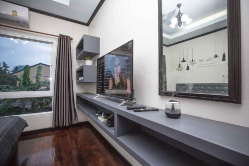 a room with a desk with a television and a window at Beautiful apartment in Ban Thalat Choeng Thale
