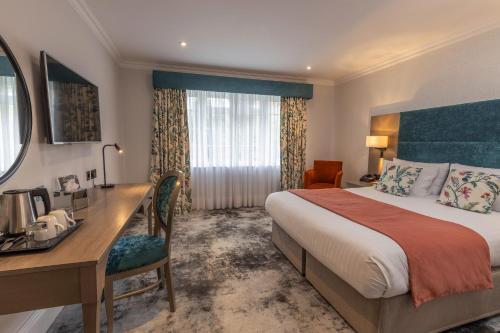 een hotelkamer met een bed en een bureau bij Best Western Abbots Barton Hotel in Canterbury