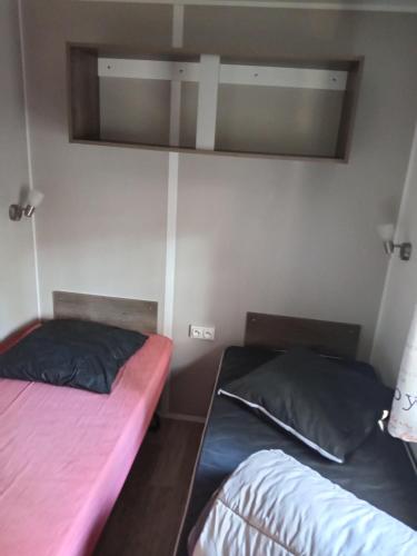 a bedroom with two beds and a mirror on the wall at Chez Nini et Pat in Le Verdon-sur-Mer