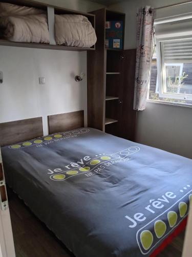 a bed with a blue comforter on top of it at Chez Nini et Pat in Le Verdon-sur-Mer