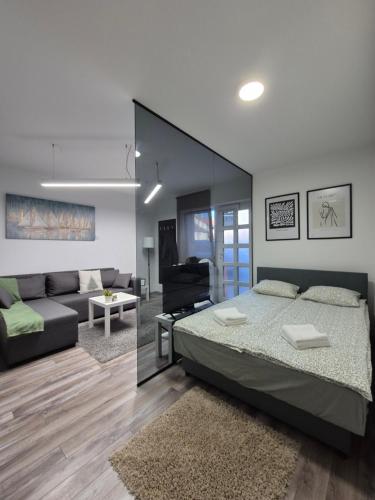 a bedroom with a bed and a living room at Studio Apartman 47A in Valjevo