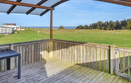 a deck with a table and a view of a field at Pet Friendly Home In Hanstholm With Private Swimming Pool, Can Be Inside Or Outside in Pugdal