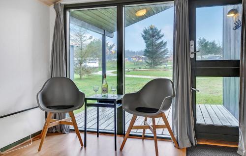 two chairs and a table in front of a window at Pet Friendly Home In Hanstholm With Private Swimming Pool, Can Be Inside Or Outside in Pugdal