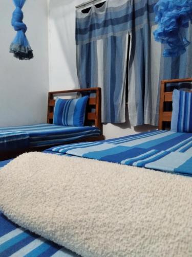 Una cama o camas en una habitación de Sigiriya Lions Rest Hostel