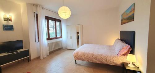 a bedroom with a bed and a flat screen tv at Maya Suite & Garden in Sarteano