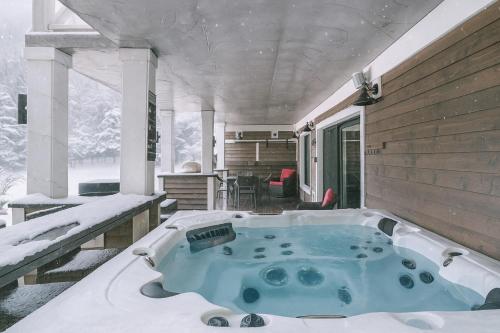 a jacuzzi tub in the snow on a house at Escale Vélo & Spa en Estrie in Shefford