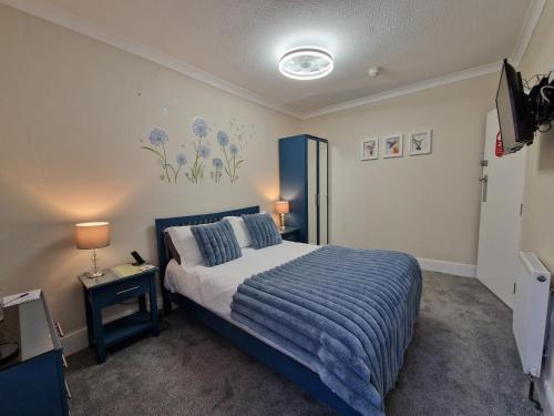 a bedroom with a bed and a tv in it at Ambassador Guest House in Paignton