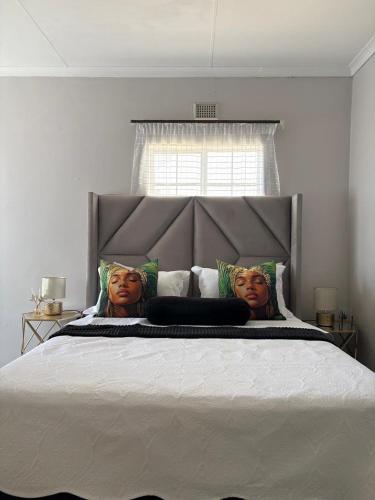 a bedroom with a large bed with two faces on the pillows at 33 Boeren in Vryheid