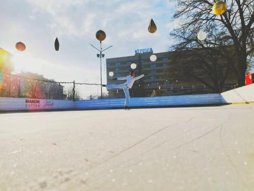 a woman is playing with balls in a parking lot at Struma Hotel in Pernik