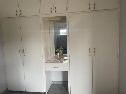 a white closet with white cabinets and a mirror at 33 Boeren in Vryheid