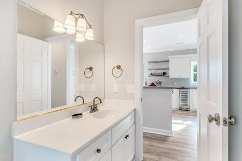 a white bathroom with a sink and a mirror at GP57: 57 Grand Pavilion in Isle of Palms