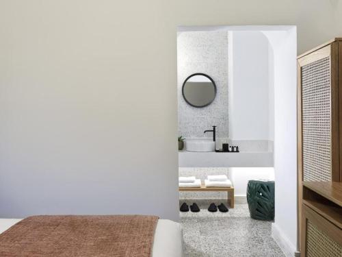 a white bathroom with a sink and a mirror at Astris Suite, Mansion Double Room, Imerovigli in Imerovigli