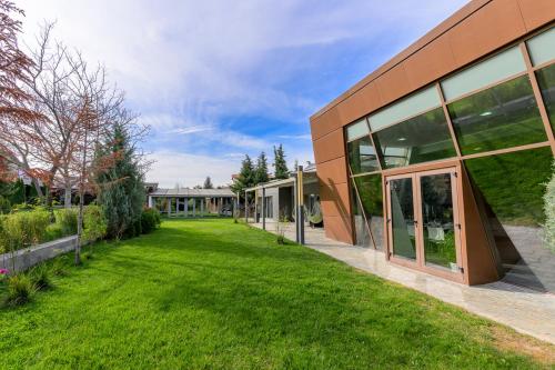 an exterior view of a building with a grass yard at 9 April Village Sea & Spa Varna in Varna City