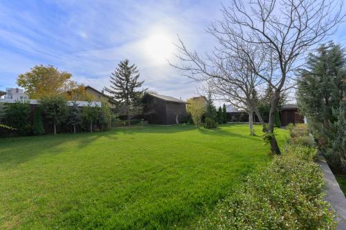 a yard with a green lawn with a house at 9 April Village Sea & Spa Varna in Varna City