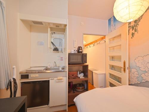 a small room with a kitchen and a bed and a sink at The Nest Koenji Cozy Stay near Station Easy Access to Shinjuku in Tokyo