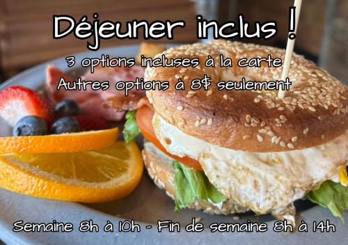 a sandwich on a plate with fruits and vegetables at Auberge Sutton Brouerie in Sutton