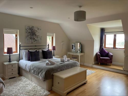 um quarto com uma cama, uma cadeira e janelas em Baytree Lodge em Weymouth