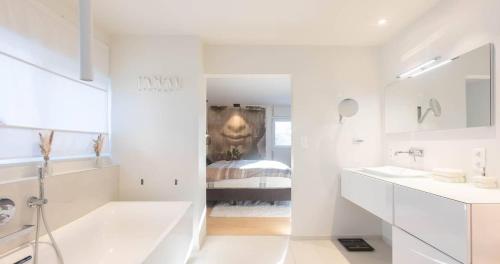 a white bathroom with a tub and a sink at Grand Spa-Francorchamps Villa - Chalourous "home sweat home" for Families, Friends & Pilots - Splendid 4-Bedroom with Home Cinema theater & pool in Spa