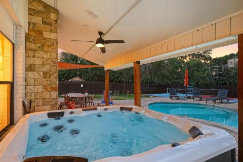 een hottub op een terras met een plafondventilator bij Pool Games Pickleball & Putt Putt Fun in San Antonio