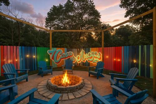 een vuurplaats met stoelen en een bord op een hek bij Pool Games Pickleball & Putt Putt Fun in San Antonio