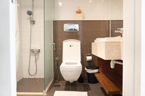 a small bathroom with a toilet and a shower at Sea View Modern 2BHK Apartment with Balcony in Ras al Khaimah