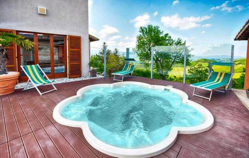 a hot tub on a deck with two chairs at 3 Bedroom Cozy Home In Sant'angelo In Vado in Piandimeleto