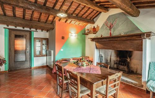 a dining room with a table and a fireplace at Pet Friendly Apartment In Castiglione Del Lago in Pucciarelli